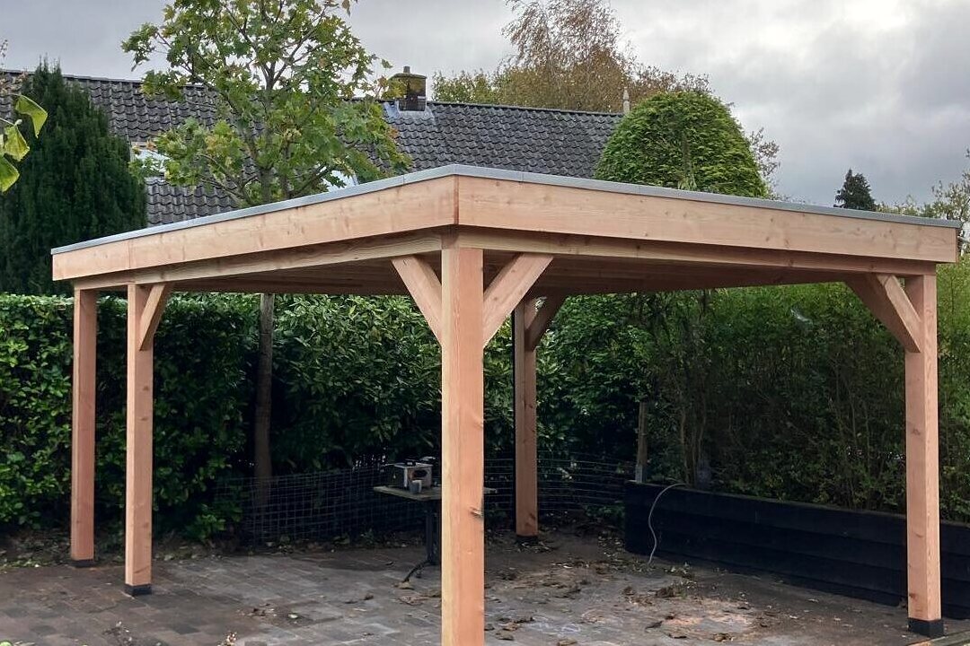 Vrijstaande douglas overkapping in Amersfoort op vier stijlen, met plat dak en zinken dakrand.