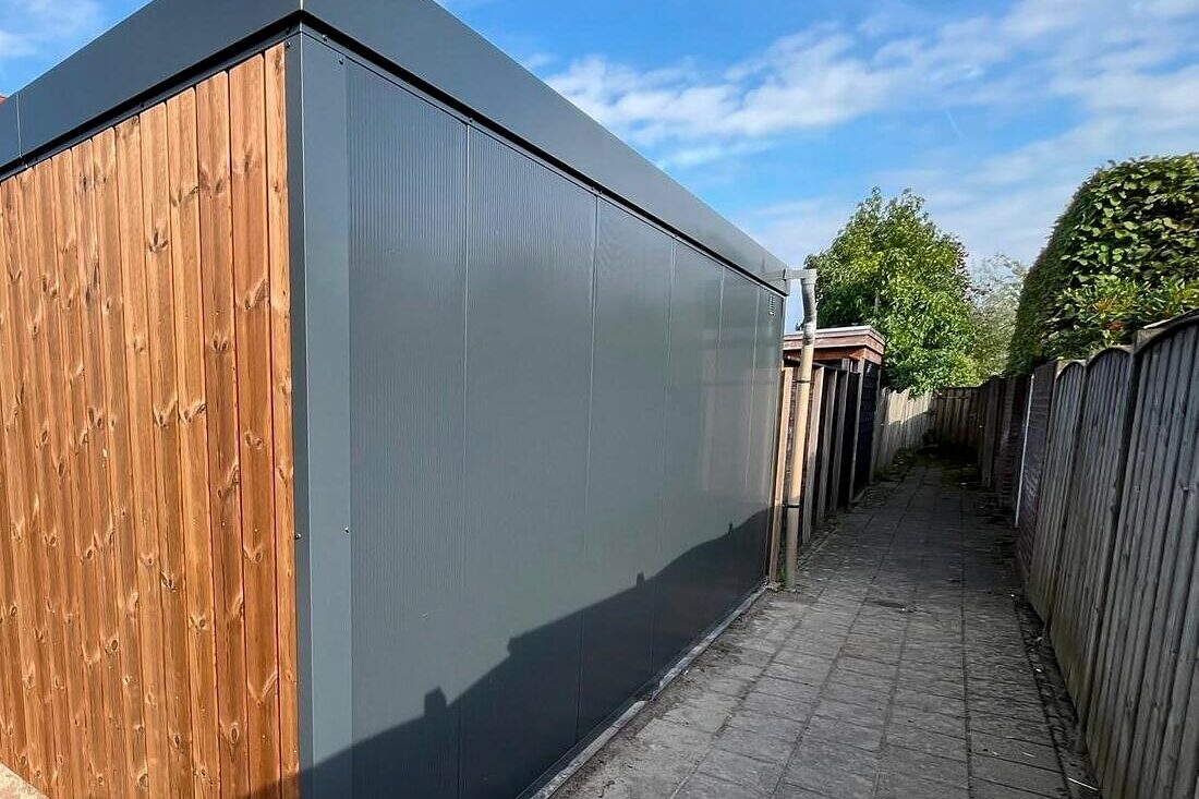 Berging in Boxtel, opgebouwd uit antracietkleurige sandwichpanelen met een thermohouten kopgevel.
